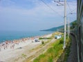 The train goes by the sea, a beach, people