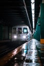 a train coming down tracks at night with it's lights on Royalty Free Stock Photo