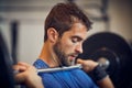 Train insane or remain the same. a handsome young man lifting weights while working out in the gym. Royalty Free Stock Photo