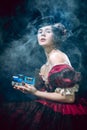 Young woman as Anna Karenina on dark blue background. Retro style, comparison of eras concept.