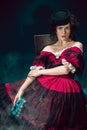 Young woman as Anna Karenina on dark blue background. Retro style, comparison of eras concept.