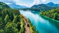 A train moves through a dense green forest filled with tall trees and lush foliage Royalty Free Stock Photo