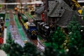 train with multi-colored Lego cars passes through huge city with tall buildings trees grass everything is created from