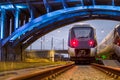 Train Paring under lit bridge Royalty Free Stock Photo