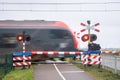 A train passes a railway crossing at high speed Royalty Free Stock Photo