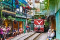 Train passing narrow road in old town in Hanoi