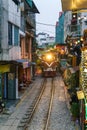 Train passing narrow road in old town in Hanoi