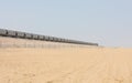 Train passing a railway in the desert. Royalty Free Stock Photo