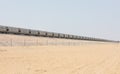 Train passing a railway in the desert. Royalty Free Stock Photo