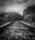 Train rail track into the distance leading between rocky hill Royalty Free Stock Photo