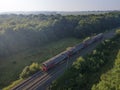 Train on Railroad in summer forest in foggy sunrise. Top Aerial view rural railway