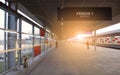 Train on the railroad tracks during sunset. Perron at the train station. Royalty Free Stock Photo