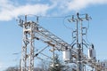 Train or railway power line support. Railway power lines with high voltage electricity on metal poles against blue sky. Royalty Free Stock Photo