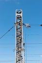 Train or railway power line support. Railway power lines with high voltage electricity on metal poles against blue sky. Royalty Free Stock Photo