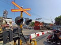 A Train with a Red and Blue Locomotive Crossing a Crowded Road