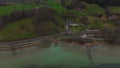 Train rides along Lake Tegernsee in upper Bavaria, Germany aerial view. Drone view of a railroad track along beautiful