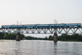 The train is riding over the bridge over the river at sunset Royalty Free Stock Photo