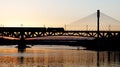 The train riding over the bridge over the river at sunset. Royalty Free Stock Photo