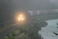 Train Rolling Along River in Fog Royalty Free Stock Photo