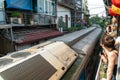 Train running on railway road with tourist watching the train from railway cafe in Hanoi, Vietnam