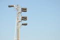 Train semaphore light with six lamps at a high gray concrete pillar against blue sky
