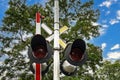 Railway crossing lights on a blue cloudy sky