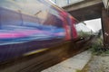 Train speeding in blur under bridge Royalty Free Stock Photo