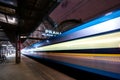 Train speeding through railway station with extended motion. Royalty Free Stock Photo