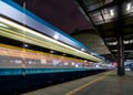 Train speeding through railway station with extended motion. Royalty Free Stock Photo