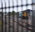 Train at station behind railings