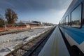 Train station is being renovated, trains stopped at a station and a closed train track with freshly built rails and sleepers is