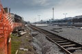 Train station is being renovated, trains stopped at a station and a closed train track with freshly built rails and sleepers is