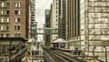 Train Station on Elevated tracks within buildings at the Loop, Glass and Steel bridge between buildings Chicago City Center - Dark Royalty Free Stock Photo