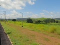 Train station in Konkan with grass field and mountains in the background. Royalty Free Stock Photo