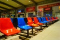 Train station passenger waiting area, rows of chairs and a number of male and female passengers