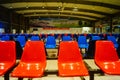 Train station passenger waiting area, rows of chairs and a number of male and female passengers