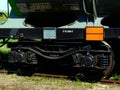 Train steel wheels close-up with overgrown steel rails