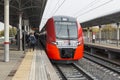 Train `Swallow` arrives at the passenger platform station `Botanical Garden` of the Moscow central ring Royalty Free Stock Photo