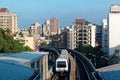 View of a train traveling on elevated tracks of Taipei Metro System between office towers under blue clear sky Royalty Free Stock Photo