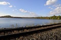 Train track with beautiful blue sky with clouds, lake, autumn leaf color