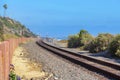 Train track in San Clemente, California with wooden posts barrier on the left