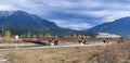 Train tracks bridge passing over river with the Canadian Rockies Royalty Free Stock Photo