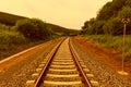 Train tracks goes to horizon in the majestic sunset. Landscape in mountains Royalty Free Stock Photo