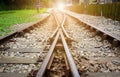 Train tracks on gravel, two of railways tracks merge with sunset background, concept of success