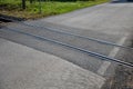 Train tracks leading across the asphalt road obliquely to the direction of travel. there is a risk of an accident of single-track