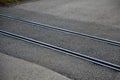 Train tracks leading across the asphalt road obliquely to the direction of travel. there is a risk of an accident of single-track