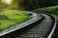 train tracks in nature with sunset. The track is curved. trees and hills on both sides. atmosphere in the morning