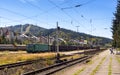 Train tracks in Predeal city on a sunny day, with Clabucet Ski Slope visible in the background