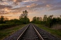 Train tracks in rural landscape and sunset Royalty Free Stock Photo