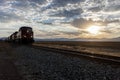 Train on tracks at sunrise. Royalty Free Stock Photo